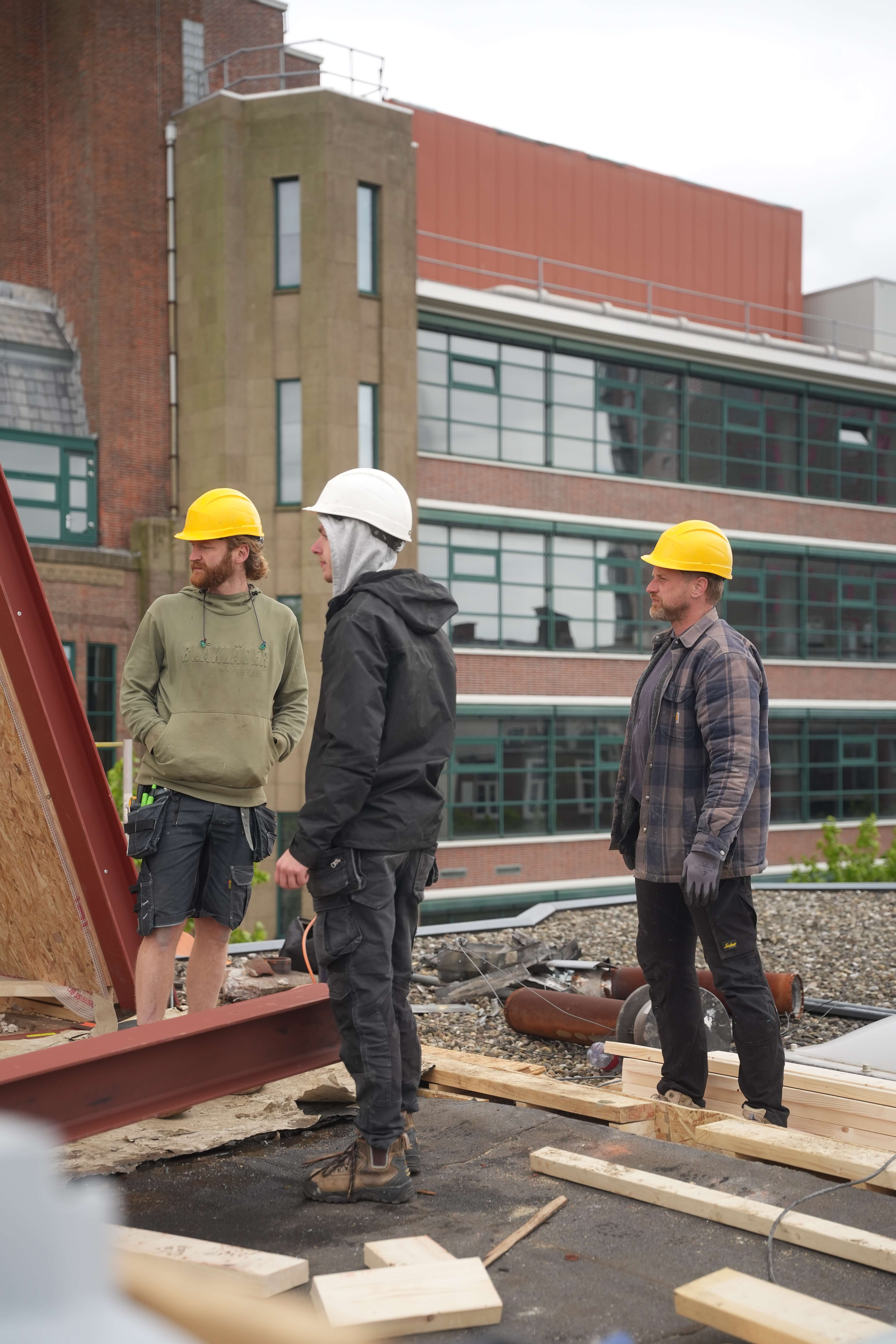 Uitvoerder van SR Bouw overlegt met het team op de bouwplaats