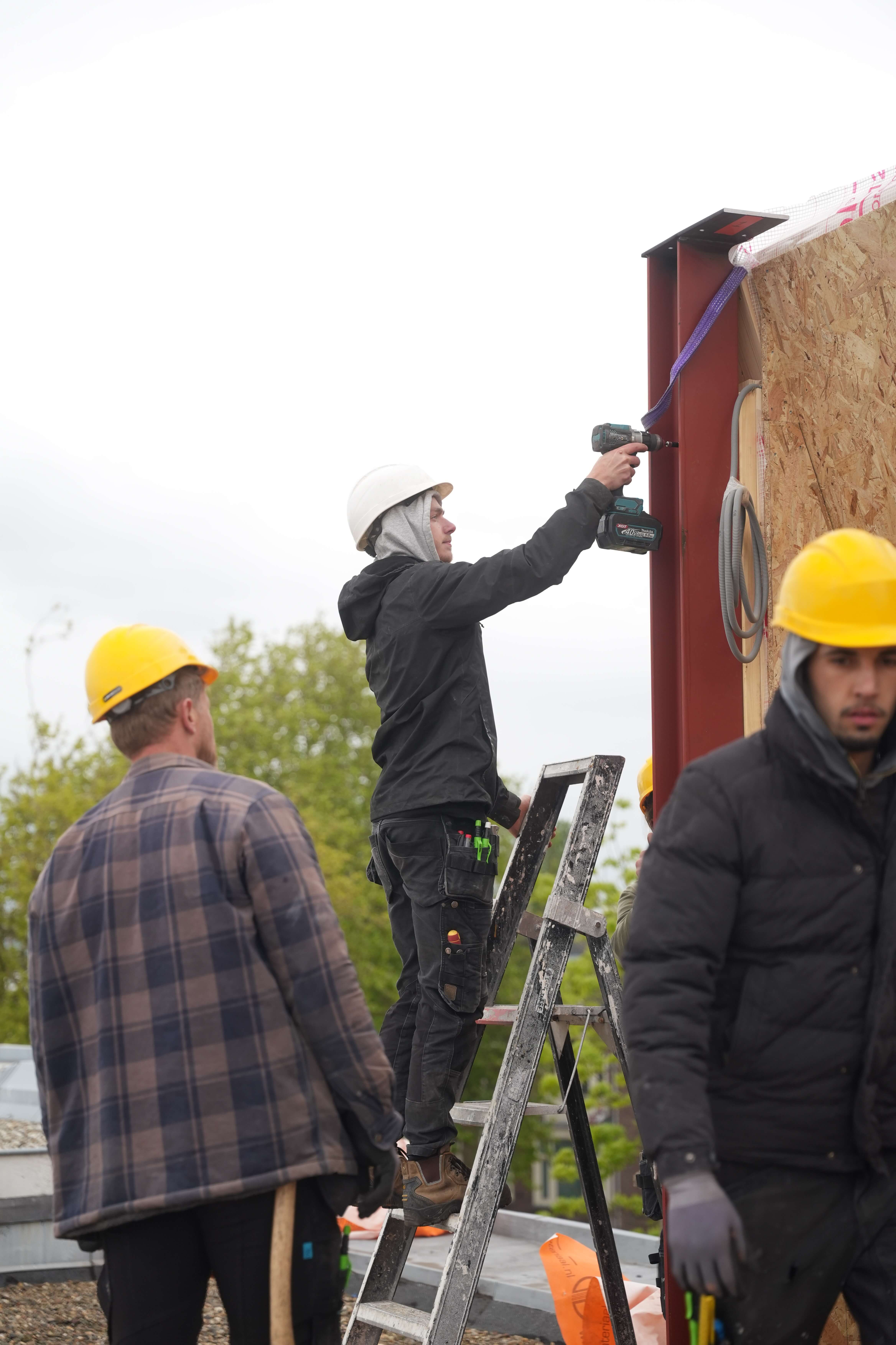 Team van SR Bouw stelt een prefab wandelement af op het dak