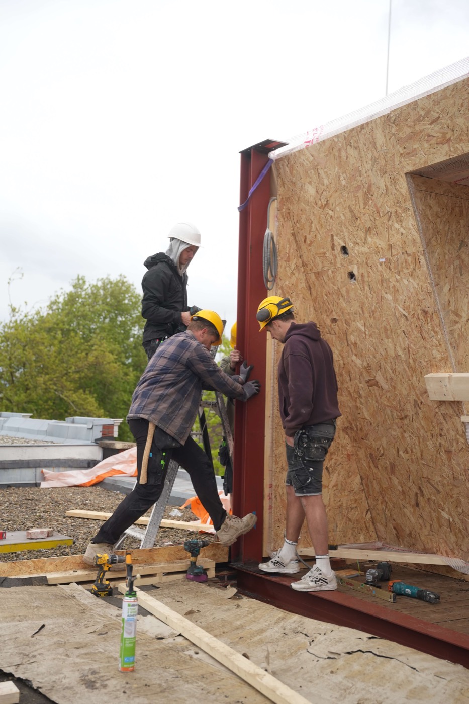 Prefab wandelement wordt met een kraan op het dak geplaatst