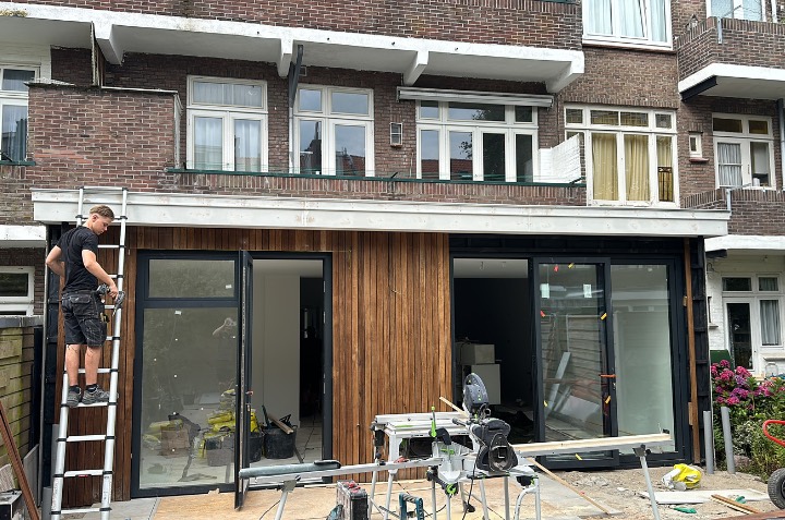 Aanbouw met houten gevelbekleding en glazen puien in Den Haag